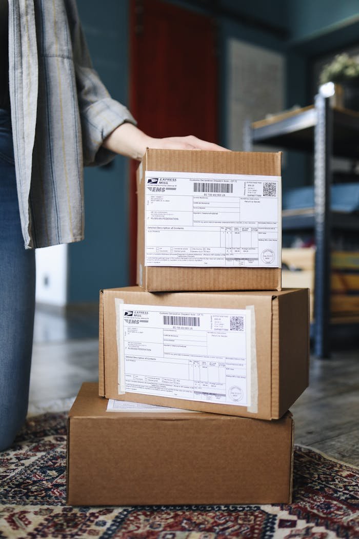 Contacto paquetería Badalona. A stack of brown cardboard boxes with shipping labels ready for mail delivery.